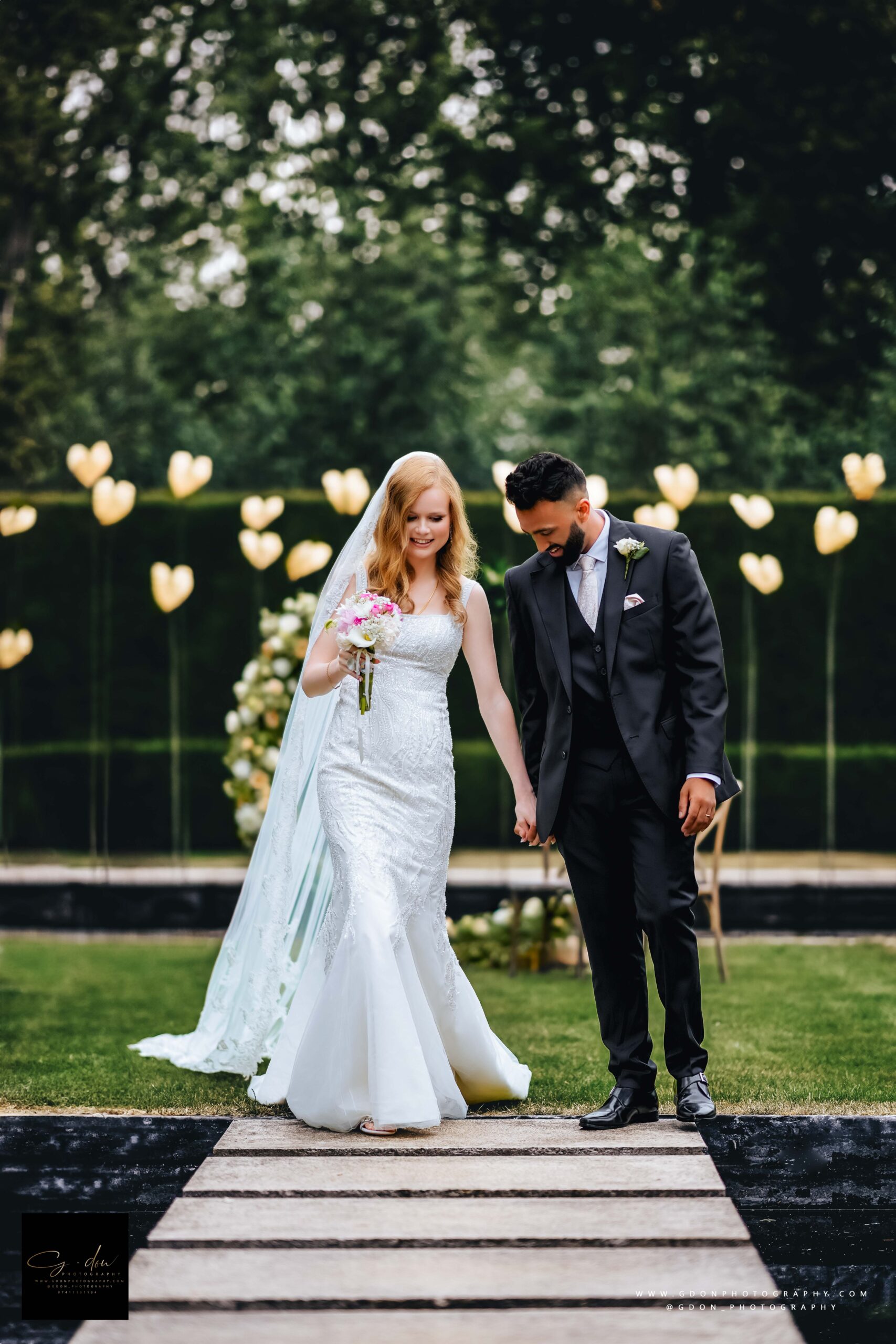 Bride and groom walking in water garden